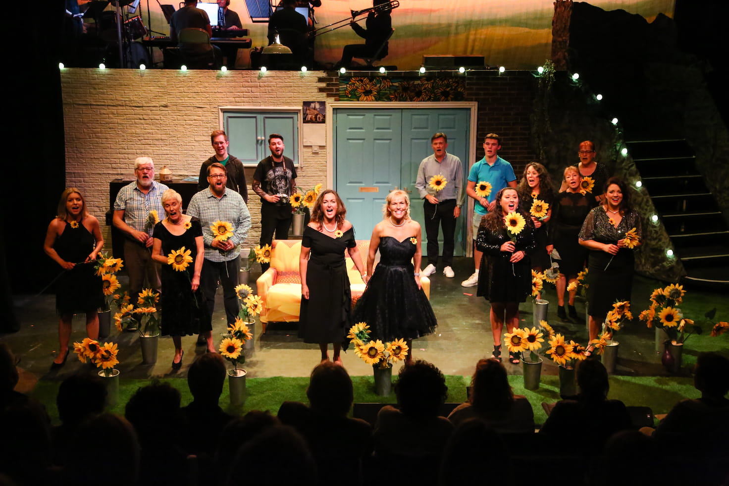 The cast on stage surrounded by sunflowers during the final scene, taken during one of the performances.